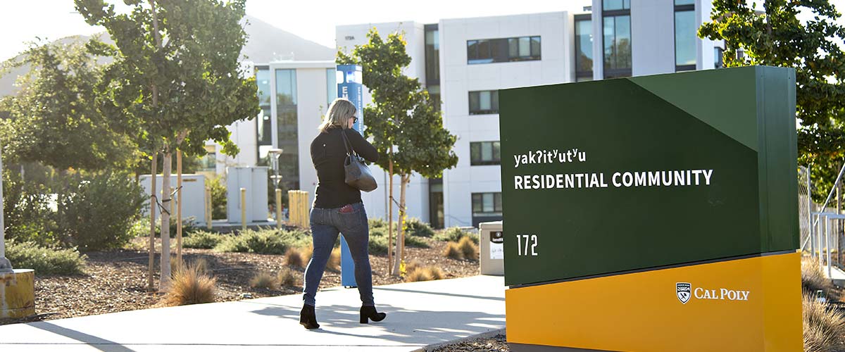 Students walk past a new wayfind sign near the dorms