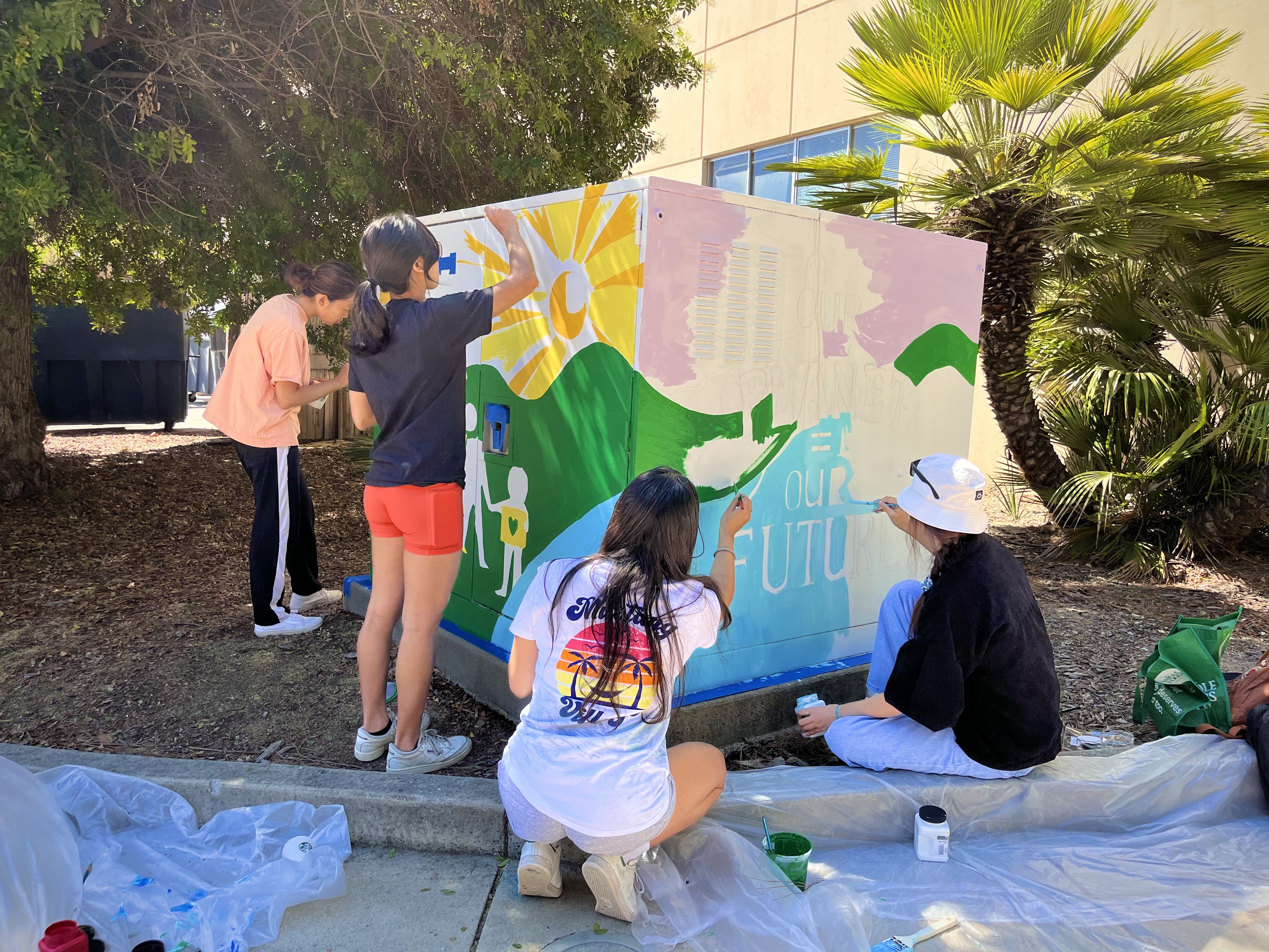 Team working together putting art on the utility box
